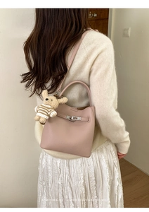 Detail der rosa Bucket Bag aus strukturiertem Leder mit silbernem Schloss und Bärenanhänger
