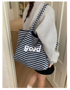 Detail view of the large capacity striped canvas tote bag with good print on model