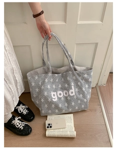 Detail view of large grey canvas tote bag with stars print and good lettering