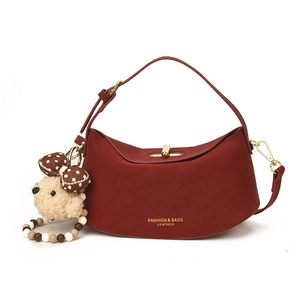 Sac à bandoulière bordeaux en forme de demi-lune avec un joli porte-clés ourson