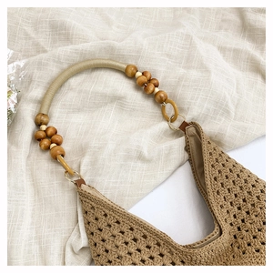 Detail of hollow crochet tote bag with wooden bead shoulder straps and geometric texture