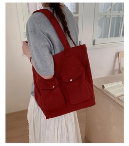 Nahaufnahme der dunkelroten Canvas-Tasche mit Frontpattentaschen und Metallschnalle