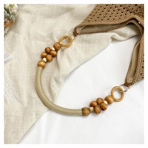 Close-up of brown crochet tote bag with wooden bead straps and a metal zipper closure