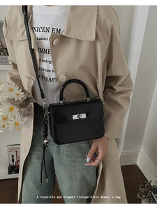 Retro schwarze Umhängetasche mit Silberverschluss in einer Lifestyle-Straßenszene