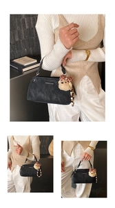 Detail of black textured crossbody bag with a cute teddy bear charm and fashion logo