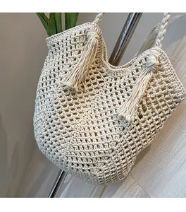 Détail du sac cabas en coton crocheté avec motif en losanges et pendentifs à pompons