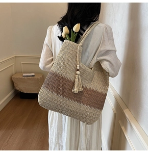 Detailed macro of a woven straw tote with wooden bead tassels and gradient color panels