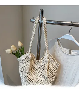 Détail du sac cabas tissé crème avec motif en maille ajourée, pompon et bandoulière robuste