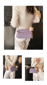 Detailed view of purple leather crossbody bag with plush bear charm and beaded strap