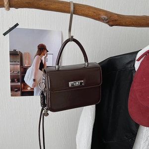 Detail der vintage schokobraunen Kunstledertasche mit silbernem Drehverschluss und Tragegriff