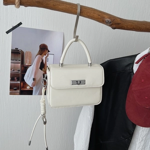 Weiße Mini-Handtasche mit silbernem Drehverschluss und gewebtem Riemen am Ast-Detail