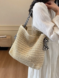 Woven straw tote bag with black and white geometric pattern strap for summer beach vacation