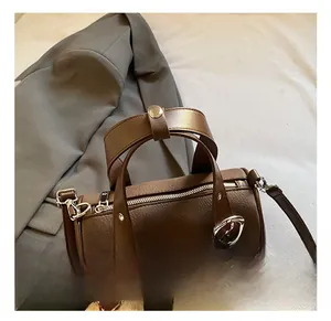 Detail of dark brown leather bowling bag with silver hardware and plush ball charm