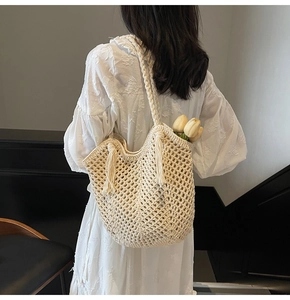 Détail d'un sac cabas en crochet fait main crème avec motifs ajourés et longues franges latérales