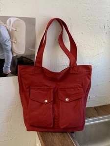 Ziegelrote Canvas-Tragetasche mit Vordertaschen und Silberknöpfen für den Alltag