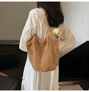 Détail du sac fourre-tout tissé kaki avec design en maille ajourée et pompon décoratif
