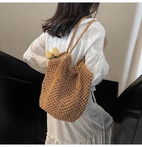 Détail du sac cabas en paille tissé main avec pompon élégant et texture crochet