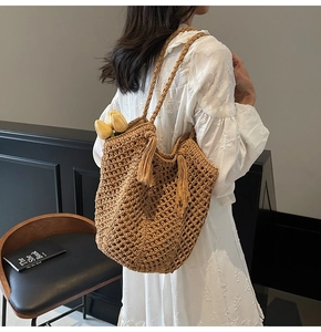 Détail du sac cabas tissé ajouré avec pompon à franges et texture coton marron