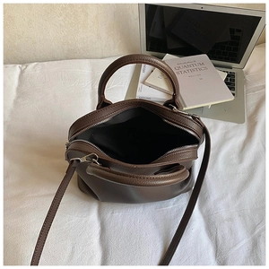 Top view of open brown pebbled leather shell bag with adjustable strap and dual zippers