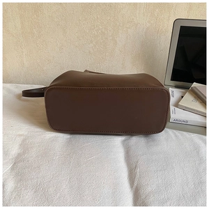 Detailed bottom view of large brown leather shell bag showing precise stitching crafts