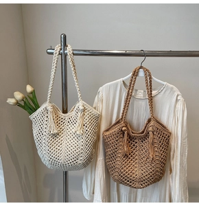 Détail de sacs fourre-tout tressés à la main avec poignées épaisses et breloques à pompons
