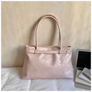 Détail du sac cabas rose clair avec rivets argentés et design élégant de bureau