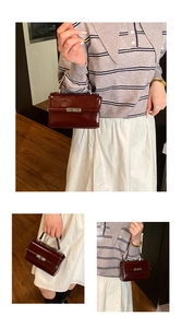 Detail of dark red glossy leather handbag featuring silver metal lock and sturdy handle