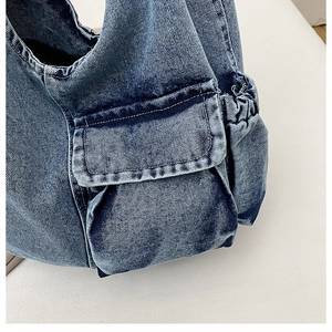 Close-up of vintage denim tote bag showing cargo pockets and white contrast stitching
