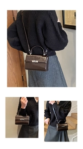 Detail view of a brown glossy leather mini bag with silver clasp and top handle strap