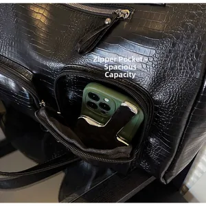 Detailed view of the side zipper pocket on a crocodile texture tote bag with a smartphone