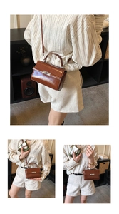 Detail view of dark brown glossy leather handbag with silver metallic buckle and strap