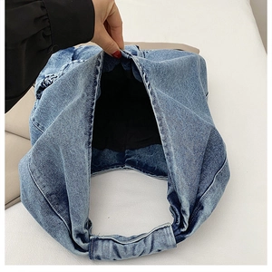 Detail view of denim tote bag showing spacious black lining and thick integrated strap