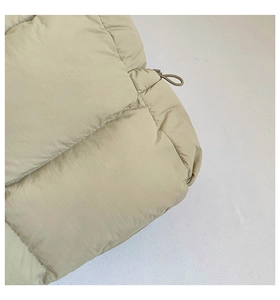 Détail du matelassage horizontal sur un sac bouffant beige avec boucle de cordon réglable