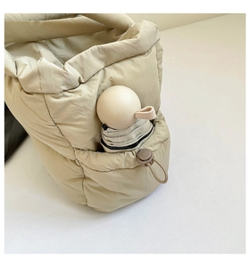 Détail du sac cabas matelassé montrant la poche latérale pratique pour ranger un parapluie