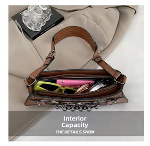 Interior view showing capacity of a brown woven shoulder bag with sunglasses and cosmetics