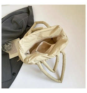 Top view of beige quilted tote bag showing interior lining and zipper side pocket