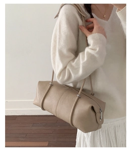 Minimalist beige leather cylinder tote bag shown on model for a stylish lifestyle look