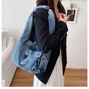 Detailed side view of blue washed denim hobo bag featuring a practical flap pocket