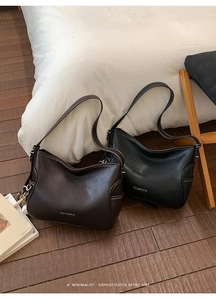 Close-up of vintage large capacity leather tote bags in brown and black with sphere charms