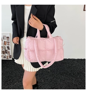 Detailed view of pink quilted puffer tote bag with stitched square pattern and soft straps