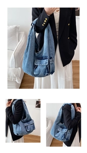 Detail view of the vintage denim tote bag featuring a large front flap pocket and washed fabric