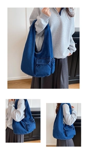 Detailed view of dark blue denim tote bag with functional utility cargo pocket