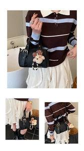 Detail of black bowling bag with bear charm, pearl beads and adjustable shoulder strap