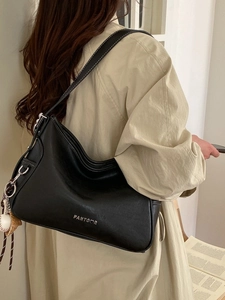 Vintage black leather tote bag with white contrast stitching and baseball charm