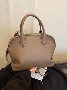 Shell shaped apricot leather handbag with pebble texture and adjustable shoulder strap
