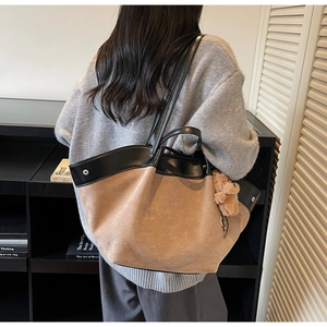 Détail du sac cabas en daim et cuir avec breloque ours en peluche et boucle métallique
