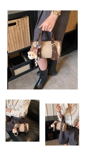 Detail of vintage boston bag featuring contrast leather, silver hardware, and bear charm