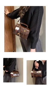 Detailansicht einer schokobraunen PU-Ledertasche mit goldener Schnalle und Bommelanhänger