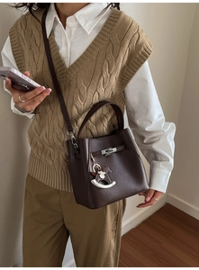 Detail of brown litchi pattern leather bag with silver twist lock and horse charm