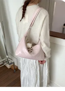 Detail of pink pleated half-moon bag with a white plush doll charm and retro PU texture